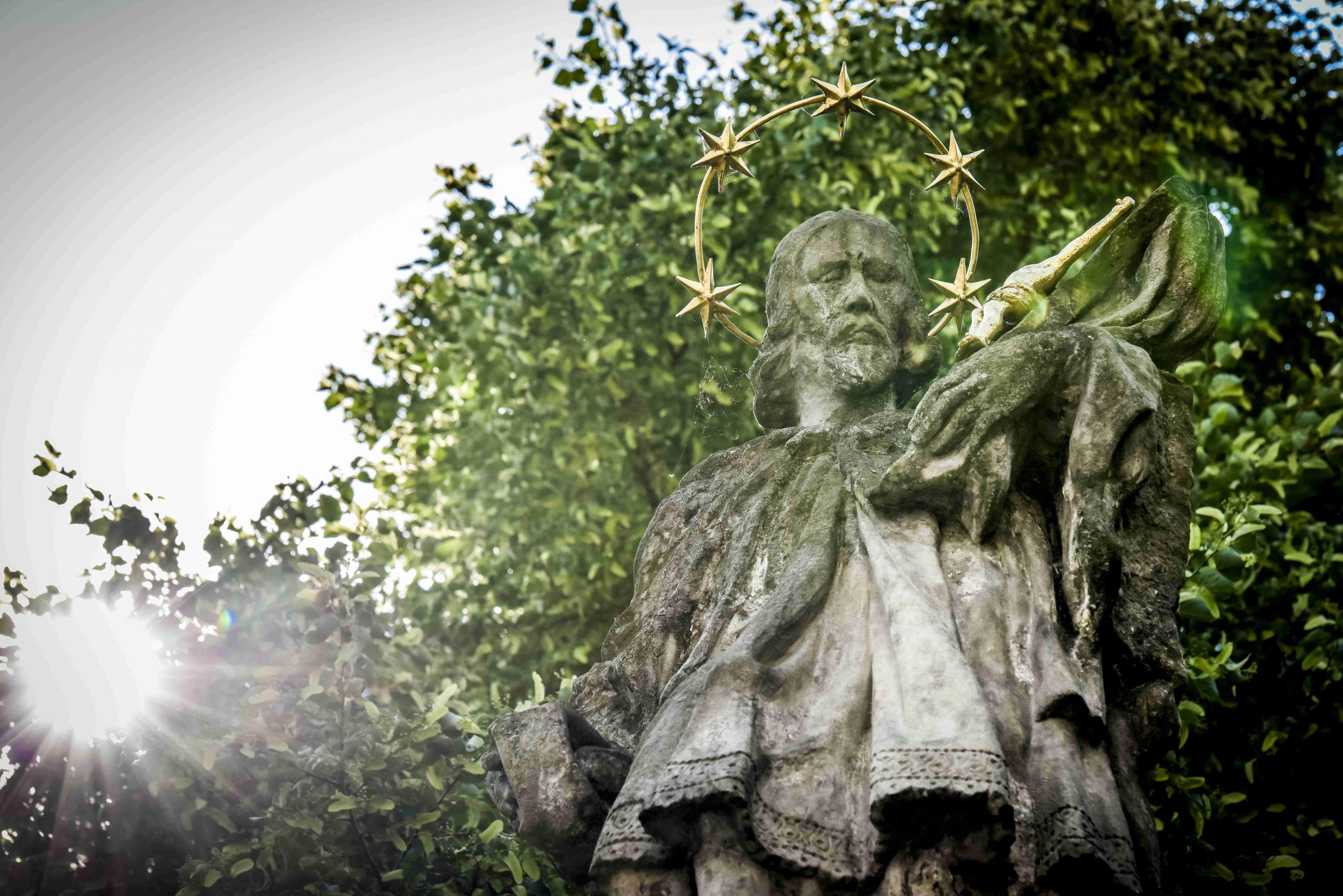 Koruna stromu chrání sochu sv. Jana Nepomuckého