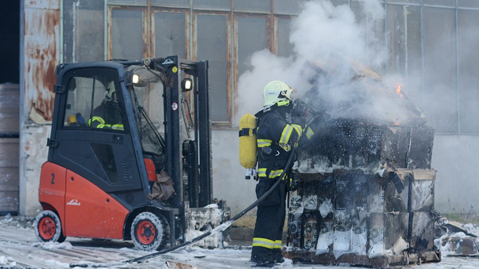 Hasiči zasahují u požáru haly v Černé za Bory - nejdříve musí hořící krabice vyvézt, následně je dohašují