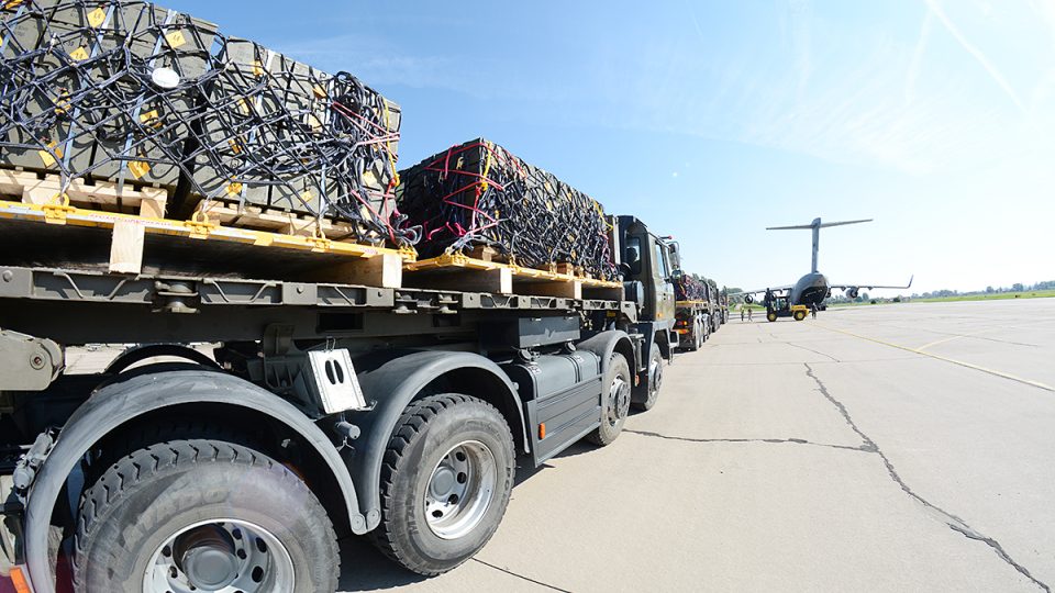 Nákladní auta přiváží náboje do letadla C-17 Globemaster III