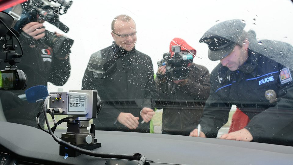 Ředitel policie Pardubického kraje Jan Švejdar přebírá vůz od hejtmana Martina Netolického pod dohledem dvou televizních a dvou policejních kamer