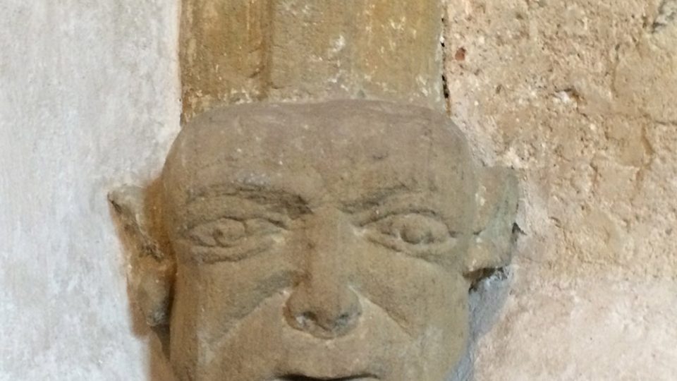 Zakončení žebroví kostela sv. Mikuláše, tahle hlava nevypadá jako cokoli ze 13. století
