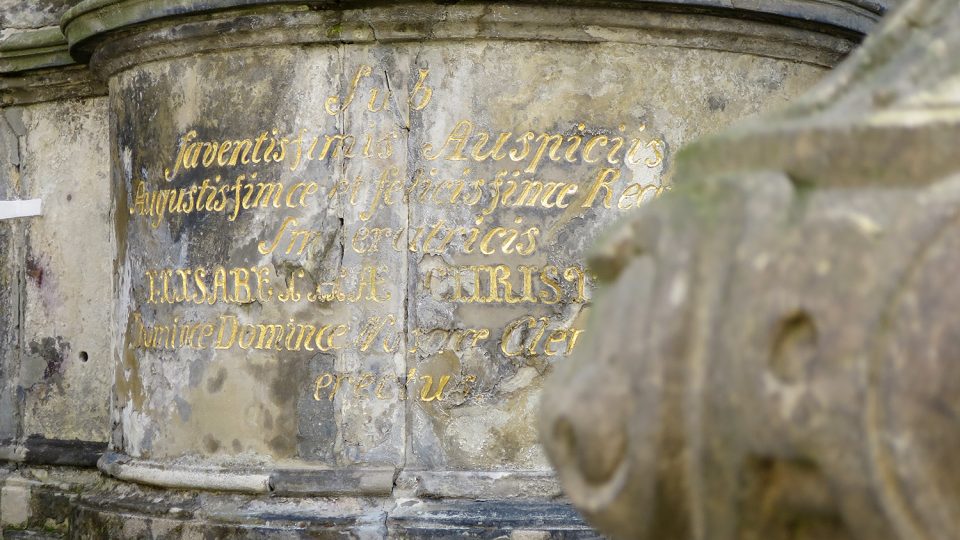 Latinský nápis na tamburu pod sochou sv Václava upomíná na záštitu císařovny Alžběty Kristiny
