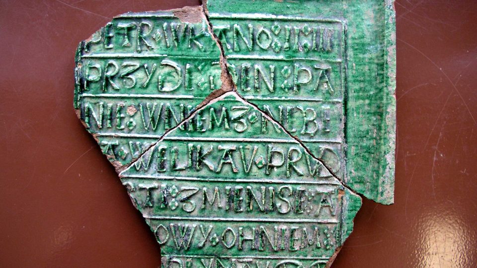 Při výzkumu na terasách Mydlářovského domu v Břetislavově ulici nyní archeologové objevili kachel s biblickým nápisem z 16. století