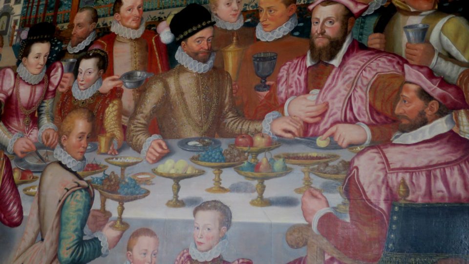 Ústřední postavou u slavnostní tabule je Jakub Hannibal I. z Hohenemsu v tmavém klobouku, naproti němu (zády k divákovi) sedí jeho švagr, kardinál Karel Boromejský