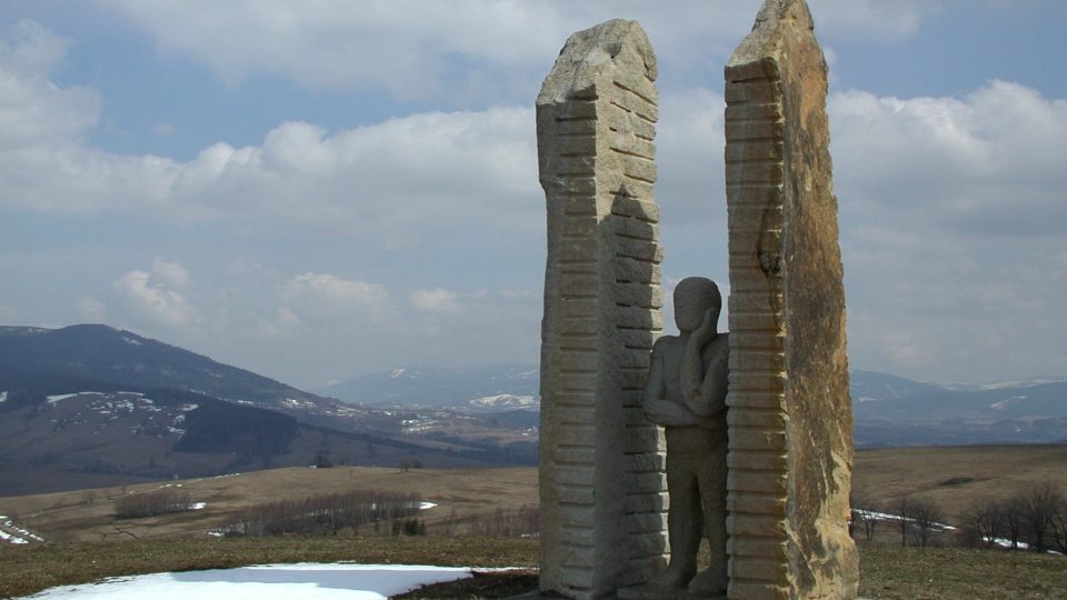 Socha Pozorovatele na Mariánském kopci vyhlíží směrem k západu. V pozadí pohoří Králícký Sněžník a Jeseníky
