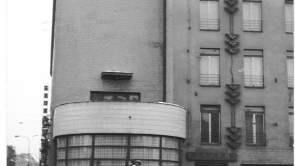 Vlajkonoš Jiří Kubík na prohnilé střeše prohnilého hotelu v prohnilém socialismu zdraví promrzlé demonstranty