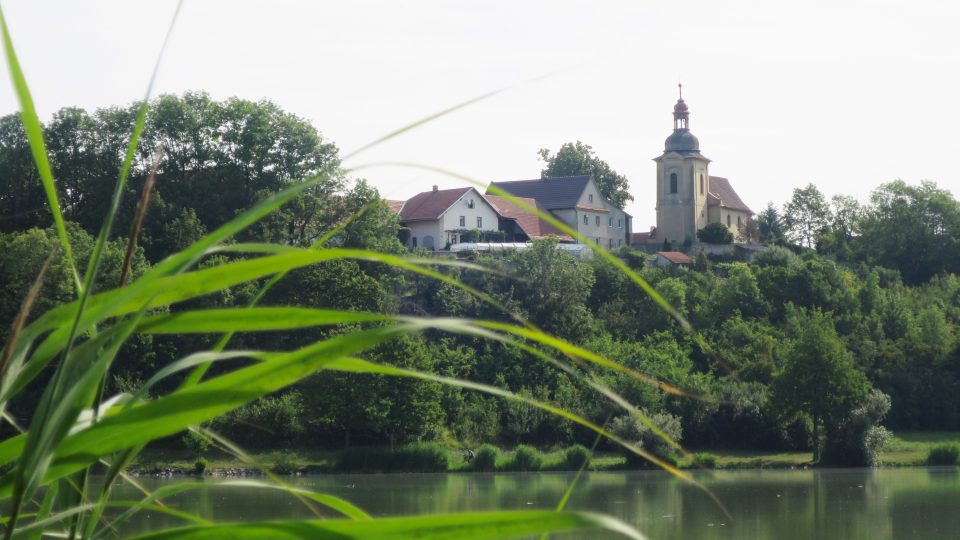Pohled od rybníka na kostel ve Voleticích