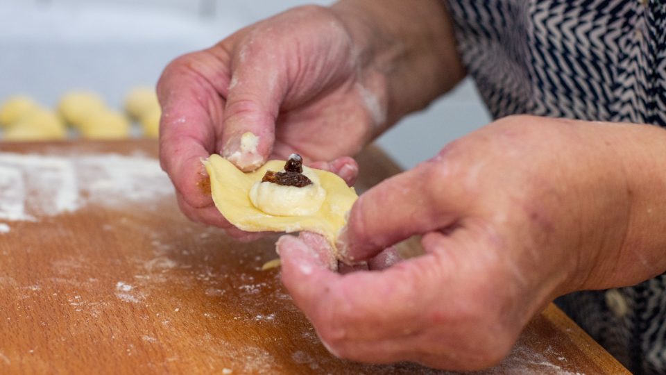 Naplněný koláček zabalíme v ruce do koule a lehce zploštíme