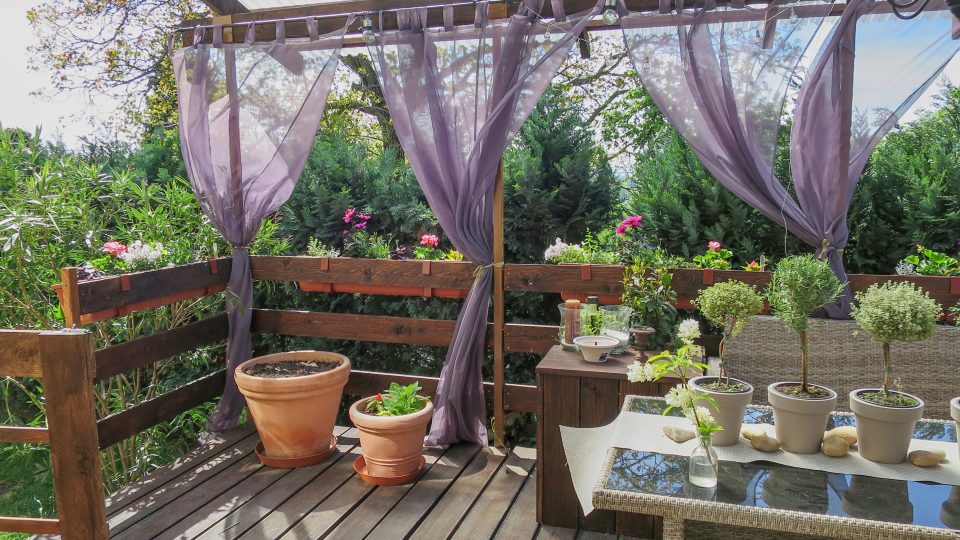 Pohled z terasy zahradníka Petra Kopáče ozdobené netradičními květinami v truhlících a vzdušnými závěsy