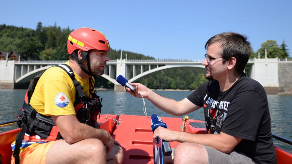 Redaktor Josef Ženatý natáčí reportáž s velitelem Michalem Jiroutem přímo na člunu