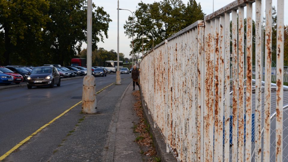Rezavý plot je první věc, kterou návštěvník po zaparkování na nábřeží uvidí
