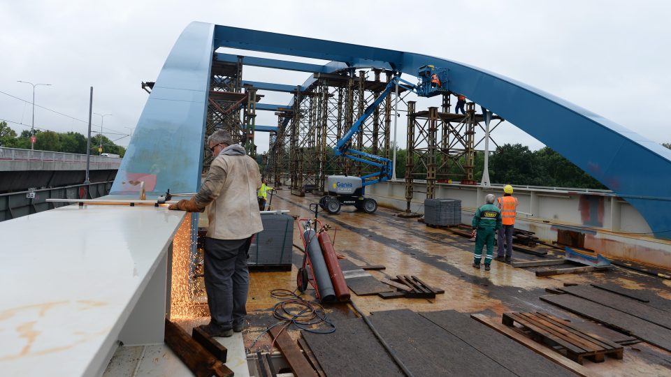 Dělníci dokončují práce na ocelové konstrukci
