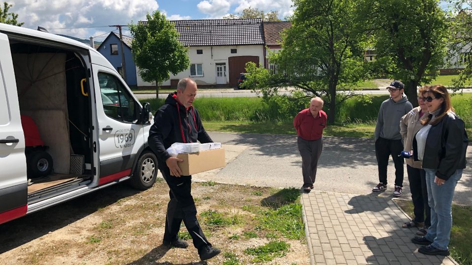 Traktůrek přijel do Suché Lozi. Výherce Josef Beníček jde špalírem pro výhru