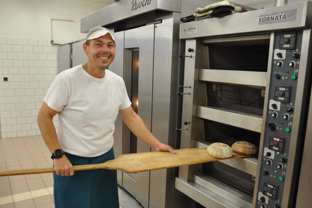Pekař David Jeřábek vytahuje z pece upečený chléb | foto: Tomáš Vlach,  Český rozhlas