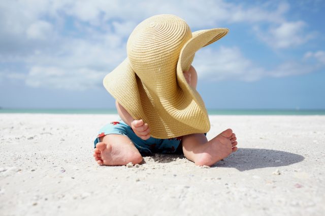 Chlapec si hraje s kloboukem na pláži | foto: Profimedia