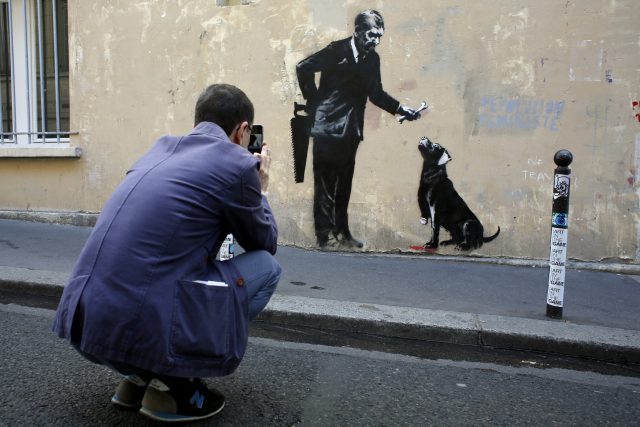Streetart graffiti známého a zatím neidentifikovaného pouličního umělce s přezdívkou Banksy | foto: Thibault Camus,  ČTK