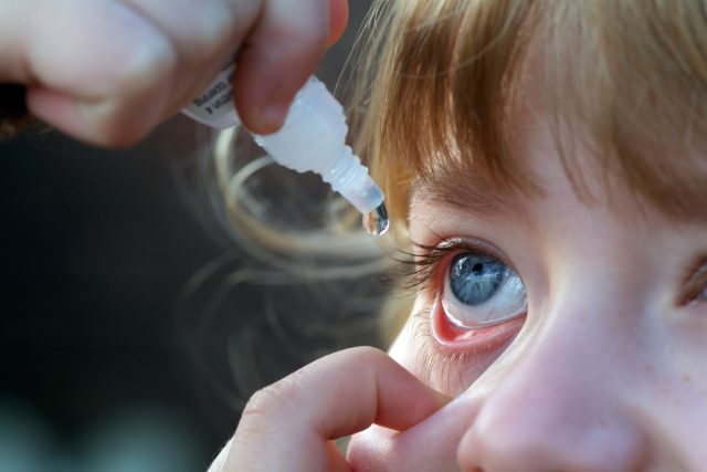 Rodiče vykapávají ditěti oči očními kapkami | foto: Profimedia