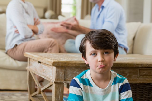 Smutný chlapec poslouchá hádku rodičů | foto: Profimedia