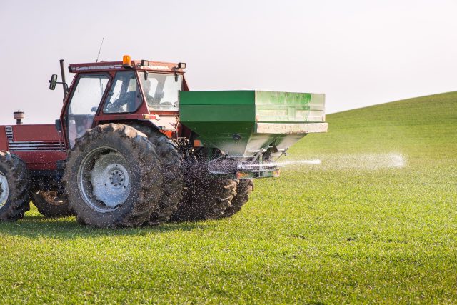 Traktor rozmetá na pole dusíkaté hnojivo | foto: Profimedia