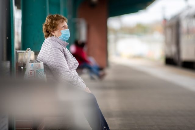 Žena v roušce čeká na vlak  (ilustrační foto) | foto: Honza Ptáček,  Český rozhlas,  Český rozhlas