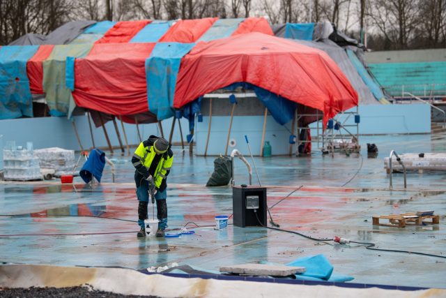 Části bazénů dělníci halí do plachty a vevnitř topí,  aby i přes noc tam byla dodržená potřebná teplota | foto: Josef Vostárek,  ČTK